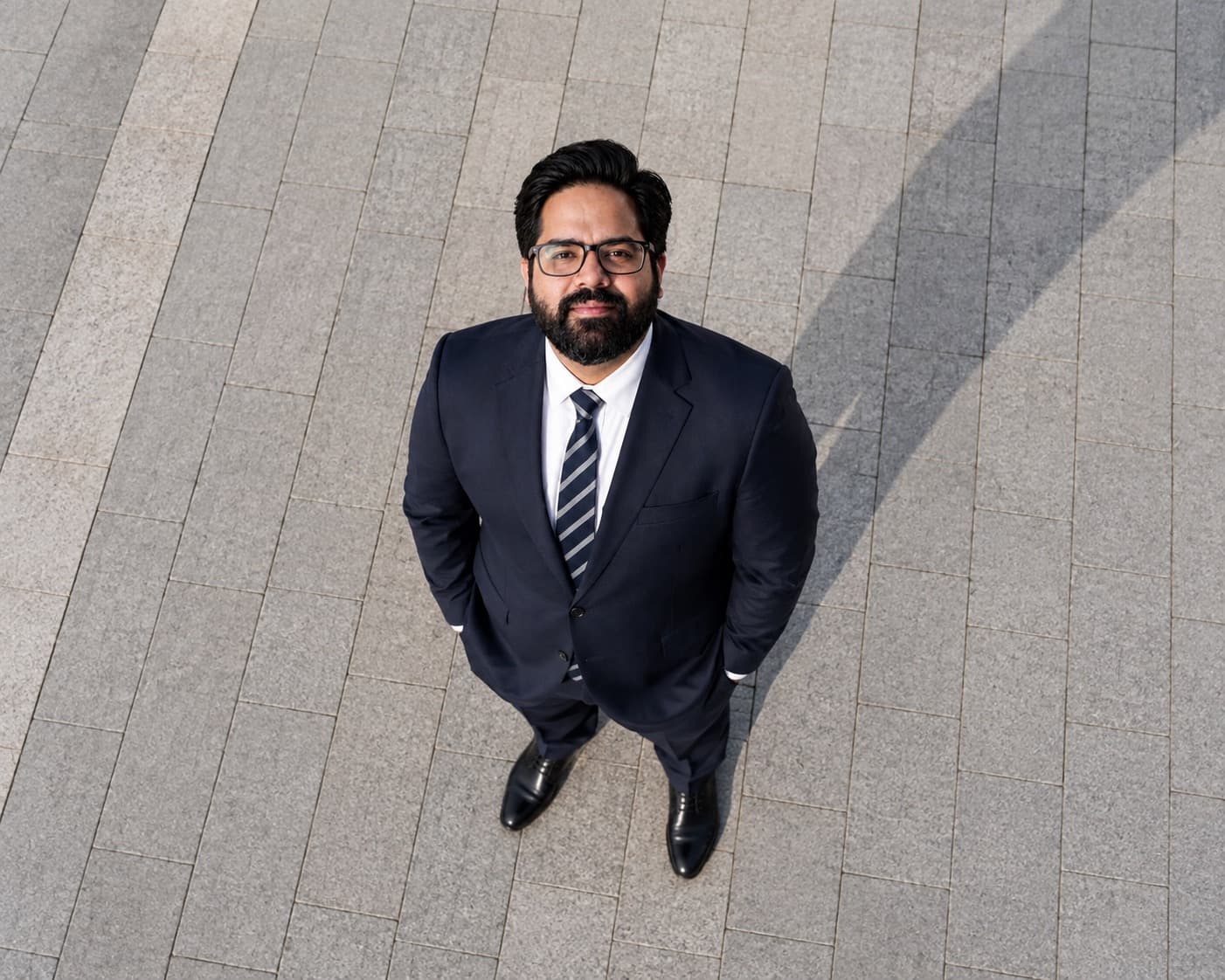 Ajit Sharma photographed from directly above, standing on a stone plaza